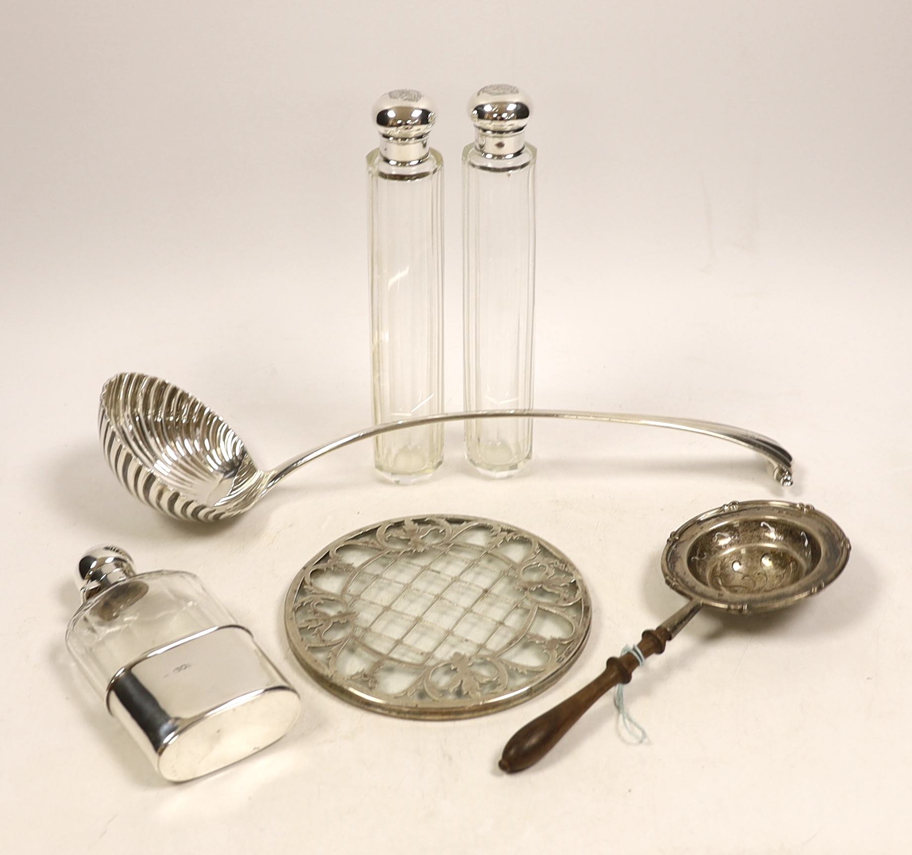 An 18th century silver base mark Onslow pattern soup ladle, indistinct marks and five other items including a silver mounted glass hip flask and a silver tea strainer with wooden handle.